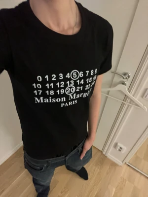 Maison Margiela svart t-shirt - Svart t-shirt från Maison Margiela. Klassisk rund krage. Skön passform och 100%  bomull. Perfekt för dig som gillar stilrena designer på tröjor.              (Pris kan diskuteras)