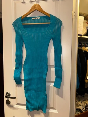Turkos ribbad långärmad klänning NA-KD - Säljer en turkos ribbad klänning från NA-KD i storlek XS. Klänningen är kroppsnära med lång ärm och fyrkantig ringning. Materialet är stretchigt och ger en snygg siluett. Perfekt för dig som gillar en enkel men ändå statement look.