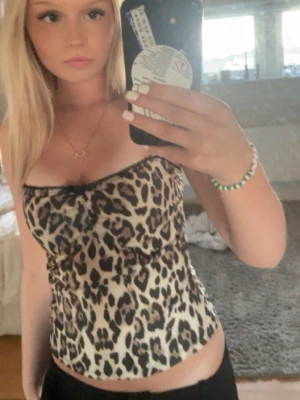 Leopardmönstrad tubtopp🫰🏼 - Säljer en snygg tubtopp med leopardmönster i beige och svart. Toppen är figurnära och axelbandslös, perfekt till sommarn eller en cool outfit
