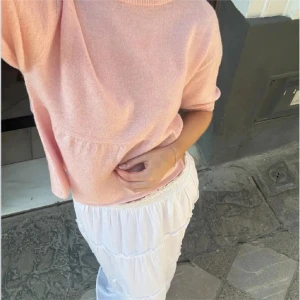 Ljusrosa blus med volang NELLY - Supersöt ljusrosa blus från NELLY med rund hals och korta ärmar