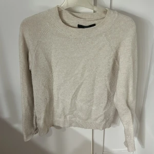 Vit stickad tröja med rund hals - Storlek M men passar bra S/XS.     Mysig vit stickad tröja med rund halsringning och ribbade muddar vid ärmslut och nederkant. Perfekt för lager-på-lager och passar till allt. Enkel och stilren design som funkar året runt.
