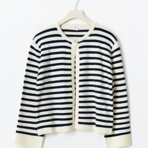 Randig kofta i marinblått och vitt - Säljer en snygg kofta med marinblå och vita ränder. Koftan har rund halsringning, lång ärm och stängs med en knapp upptill. Den är stickad och har en klassisk, avslappnad passform som funkar perfekt till jeans eller kjol.