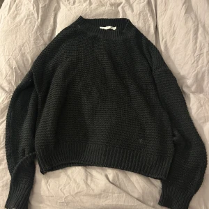 Svart stickad tröja från lager 157 XS - Svart stickad tröja från lager 157 i storlek XS. Tröjan har grovstickad struktur, rund hals och ribbade muddar vid hals, ärmslut och nederkant. Perfekt för dig som gillar en enkel och chill look med lite loose passform.