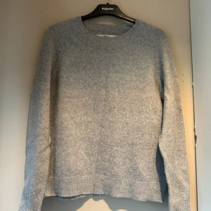 Grå stickad tröja  - En enkel och snygg grå stickad tröja från only med rund hals och ribbade muddar vid ärmslut och nederkant. 