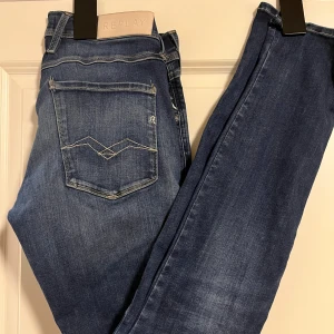 Replay Anbass jeans mörkblå herr - Storlek W31 L34. Riktigt feta mörkblå jeans från Replay. Modellen har slim passform och är tillverkad i slitstarkt denim med lätt tvättad look. Perfekt för dig som gillar stilrena jeans. Använd fåtal gånger och inga tecken på användning.