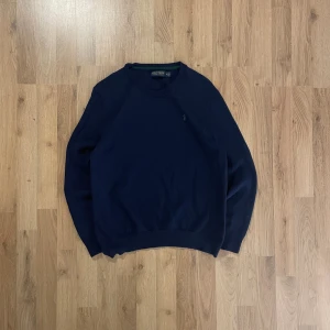 Mörkblå stickad tröja Polo Golf - Mörkblå stickad tröja från Polo Golf Ralph Lauren med klassisk rund hals och grön broderad logga på bröstet. Tröjan har ribbade muddar och är perfekt för dig som gillar en clean och tidlös stil. Passar på storlek S.  Bilder på måtten finns tillgängliga. Fråga gärna! Snabb leverans!