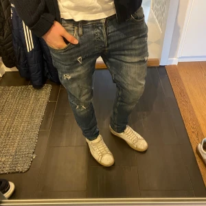jeans Jack & Jones - Säljer ett par blå jeans från Jack & Jones med slitningar och trasiga detaljer på benen. Jeansen har normal passform och sitter riktigt snyggt. Storlek 31:30