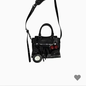 Svart axelväska  - Cool svart axelväska från New Yorker i skinn med silverfärgade detaljer och dragkedja. Väskan har både handtag och axelrem. Perfekt storlek för det viktigaste och ger en edgy vibe till din outfit.