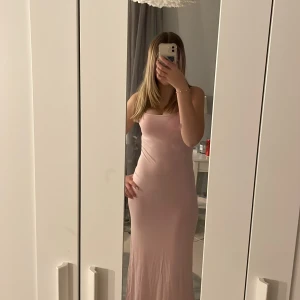 Ljusrosa långklänning från Gina Tricot - Elegant ljusrosa långklänning från Gina Tricot. Axelbandslös design som ger en stilren look. Perfekt för speciella tillfällen. Jag är 168 och klänningen är perfekt längd för mig💗