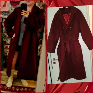 NY Vinröd kappa med bälte och knappar - Snygg vinröd kappa med dubbelknäppning och bälte i midjan. Lång modell med klassisk krage och raka ärmar. Kappan har silvriga knappar och en stilren look som passar perfekt till höst och vinter. Materialet ser ut att vara ull eller polyester.  Köpt för 539:- på shein. 