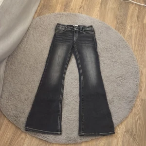 Mörk gråa jeans  - Mörk gråa jeans ifrån gina Young med glitter detalj på fickan. 