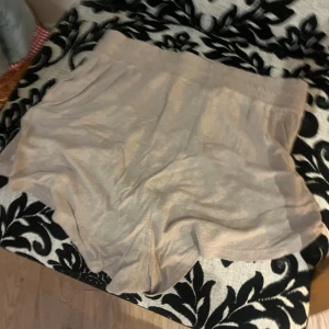 Beige loose shorts i linne - Säljer ett par superbekväma beige shorts i loose fit med bred resår i midjan. De är tillverkade i svalt linnematerial, perfekta för varma dagar. Enkel och stilren design som passar till det mesta.