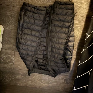 Svarta täckbyxor från Everest - Svart väst från Everest med quiltad design och dragkedja. Västen har elastisk midja och är tillverkade i ett lätt, syntetiskt material som håller värmen. Perfekta för kalla dagar och vinteraktiviteter.