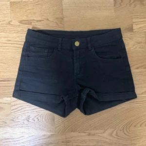 Svarta shorts med fickor - Svarta shorts med midwaist passform och klassisk femficksdesign. De har en enkel knappstängning framtill