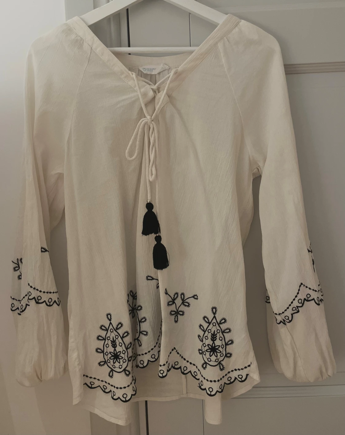 Vit blus med broderi och snörning