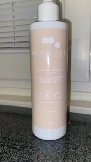 Hair Lab Biotin & Collagen Shampoo - Shampoo från Hair Lab med biotin, kollagen och arganolja. Kommer i en vit plastflaska med beige etikett, 250 ml. Ger tjockare och friskare hår, fri från sulfater och parabener, 100% naturlig och passar alla hårtyper.
