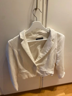 Vit kavaj - Säljer denna vita kavaj i storlek XS från fb sisters, kan ha små fläckar här och där och köparen får själv lösa tvätt. Material: polyester, elastan och viskos. Märke; fb sisters. Finns att hämta i centrala Göteborg, eller kan skickas vi valfri app. Kan behöva en tvätt pga legat i flyttkartonger pga storrensning.  