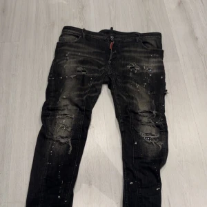 Kolla Beskrivningen  - Svarta jeans med skinny fit, slitna detaljer och färgstänk för en rå streetlook. Byxorna har låg midja och klassisk femficksdesign. Perfekta för dig som gillar en edgy stil och vill sticka ut.