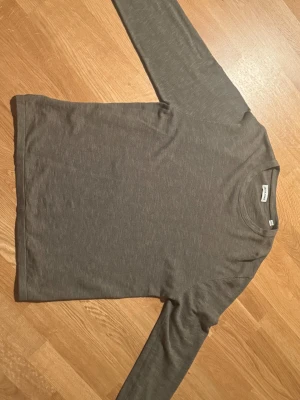 Mörkgrön långärmad tröja Jack & Jones - En enkel och stilren mörkgrön långärmad tröja från Jack & Jones. Tröjan har rund hals och är tillverkad i mjuk bomull, perfekt för chill dagar eller när du vill ha en clean look. Passformen är normal och materialet känns skönt mot huden.