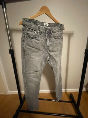 Grå jeans från 157 - Snygga grå jeans från 157 New Classic med klassisk femficksdesign och raka ben. Jeansen har en cool tvättad look och är tillverkade i slitstarkt jeanstyg. Perfekta för dig som gillar en avslappnad och stilren vibe.