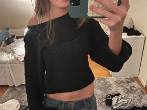 Svart  stickad tröja offshoulder - Svart stickad tröja med croppad passform och offshoulder-design. Tröjan har långa ärmar och är lite transparent i materialet.🥰