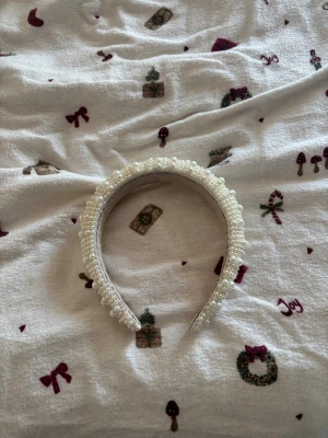 Vitt diadem med pärlor - Säljer ett diadem i vit färg, täckt med glansiga pärlor i olika storlekar för en lyxig och trendig look från Lindex. Perfekt accessoar för att lyfta din outfit. Diademet är brett och har en mjuk insida för bekväm användning. Det har aldrig kommit till använding och är endast provat. 