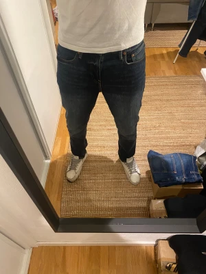 Denim &s mörkblå jeans - Säljer ett par Denim &s jeans i mörkblå tvätt med snygga slitningar. Modellen är slim fit med normal passform och raka ben. Jeansen är helt nya och har aldrig används! Därav mycket fint skick. 