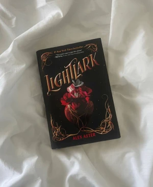 Lightlark - Upptäck 'Lightlark', en #1 New York Times bestseller med ett magiskt och mystiskt omslag. Perfekt för dig som älskar spännande och fantasifulla berättelser. Boken har fått lovord av andra författare och är ett måste för unga vuxna som vill försvinna in i en annan värld.