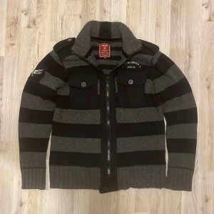 Grå stickad cardigan - Otroligt fet grå och svart stickad cardigan. Passar perfekt nu till kallare väder. Modellen är 180cm, 74kg. Storlek L men sitter som M. Priset kan såklart fiskuteras!