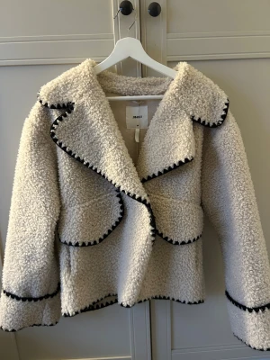 Beige teddyjacka  - Supermysig beige teddyjacka från Object med svarta detaljer längs kanterna. Säljer för att den tyvärr aldrig kommer till användningen, väldigt fint skick!!