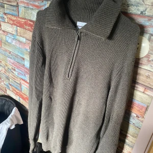 Grå stickad half zip-tröja från Bläck - Säljer en grå stickad tröja från Bläck i storlek M. Tröjan har en hög krage och en snygg half zip-dragkedja framtill. Den är så gott som ny!  Pris kan diskuteras 