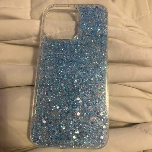 Skal iPhone 14 Pro max - Blått glittrigt skal till iPhone 14 Pro max, helt nytt aldrig använt, inga defekter