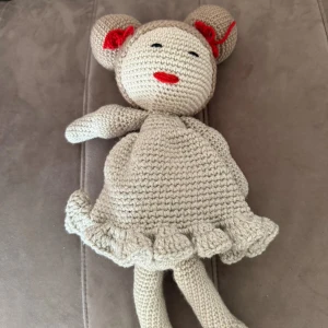 Beige virkad klänning med volangkant - Supersöt beige virkad docka med klänning med volangkant nertill. Dockan är handgjord i stickad stil och har en klassisk, rundad form. Perfekt för dig som gillar unika och gullig dockor.