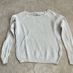 Vit stickad tröja från Size & Needle - Säljer en vit stickad tröja från Size & Needle i storlek S. Tröjan har ett grovt, ribbat mönster och rund halsringning. Tröjan har ett litet hål på framsidan (sissta bilden) men är inte så synligt och hade även gått super lätt att laga.