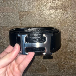 Svart bälte H märke - 110cm, oanvänd, Silver H märke