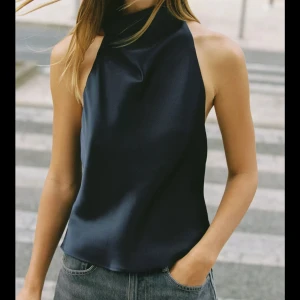 Mörkblå halterneck Zara - Säljer en helt oanvänd mörkblå halterneck topp från Zara i satinliknande material. Helt oanvänd med prislapp kvar. 