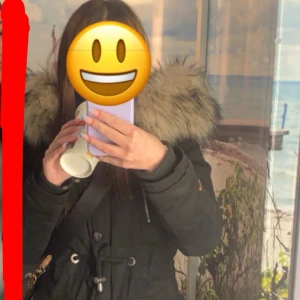 Svart parkasjacka med fuskpäls från Navahoo - Säljer en svart parkasjacka från Navahoo med stor fluffig fuskpäls runt huvan. Jackan har snörning i midjan, flera fickor med knappar och dragkedja framtill. Perfekt för kalla dagar och riktigt snygg till jeans eller leggings. Nypris 2000kr. Knappt använd! 