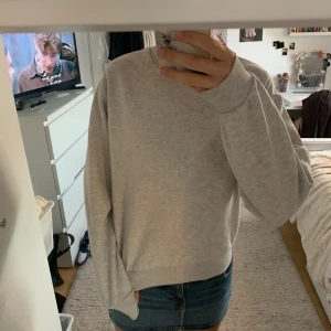 Ljusgrå basic sweatshirt - Enkel och stilren ljusgrå sweatshirt med rund halsringning och långa ärmar. Tröjan har en relaxed passform och ribbade muddar vid ärmslut och nederkant. Perfekt att slänga på sig till jeans eller shorts.