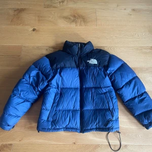 North face puffer  - Säljer en blå och svart pufferjacka från The North Face. Köpt förra året knappt använd, inga defekter 