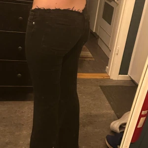 Svarta bootcut jeans med rå kant - Svarta, lågmidjade, utsvängda no-waist jeans  + spretade i botten av byxbenet pga längdens passform 💕💕