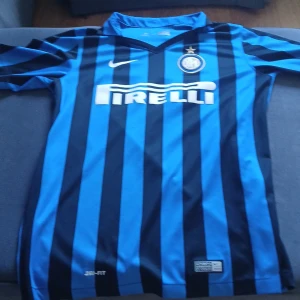Inter Milan Nike fotbollströja XL - Inter Milan matchtröja från Nike i storlek XL. Klassisk blå och svart randig design med klubbmärke och Pirelli-logga på bröstet. Tillverkad i lätt Dri-FIT polyester för bästa komfort på planen. Autentisk 2015 års modell.