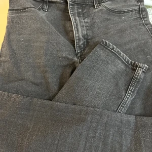 Mörkgrå jeans med raka ben - Snygga mörkgrå jeans med klassisk femficksdesign och raka ben. Jeansen har normal midja och är tillverkade i ett mjukt denimtyg som ger en skön känsla. Perfekta för dig som gillar en stilren och enkel look.