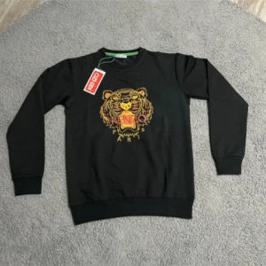 Svart Kenzo tröja med tigerbrodyr - Svart tröja från Kenzo med ikonisk tigerbrodyr i gult och rosa på bröstet. Rund halsringning och långa ärmar. Tröjan har ribbade muddar och är tillverkad i mjuk bomull. Perfekt för dig som vill sticka ut med en klassisk streetstyle-look.