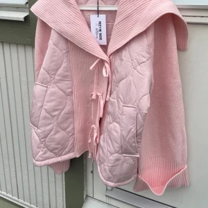Ljusrosa quiltad jacka Meet Me There - Superfin ljusrosa jacka från Meet Me There med quiltade partier och stickade ärmar. Jackan har stora fickor, bred krage och knytning framtill. Perfekt för dig som vill ha en mysig och trendig look med extra detaljer. Helt ny, aldrig använt 