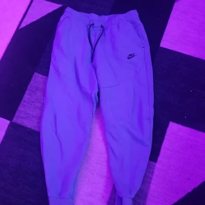 Blå nike tech nyxor - Blåa nike tech byxor i väldigt bra skick. Inga hål eller märken