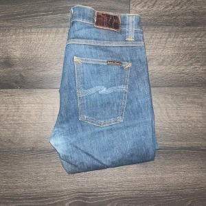 Nudie jeans Lean Dean  - Snygga blå jeans från Nudie Jeans i modellen Lean Dean. OBS jeansen kan möjligtvis vara uppsydda, inte för att jag tycker att längden är kort utan för hur kanterna är lite skrynkliga de bild! Längd 101cm, midja 36cm utgå från måtten jag tar ej emot returer :) Ifall det inte finns någon bild i annonsen där jag bär plaggen jag säljer så är det för att jag ej kan ha storleken heller passformen, så kolla måtten för storlek och googla på modellnamnet för passform 😉23