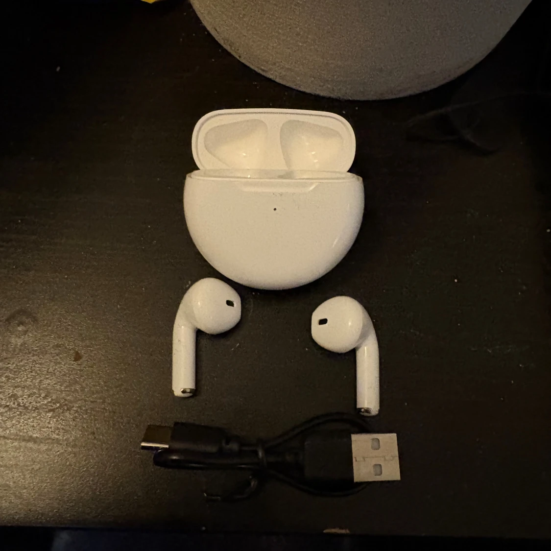 Vita trådlösa hörlurar med laddsladd