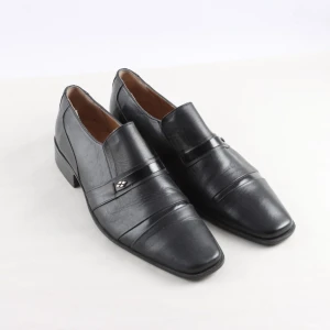 Svarta loafers i skinn med detalj - Stilrena svarta loafers från Faurk Karar i  skinn med fyrkantig tå och diskret metallogo på bandet över foten. Snygg design med låg klack och klassiska linjer, perfekta för en dressad look. Storlek 41