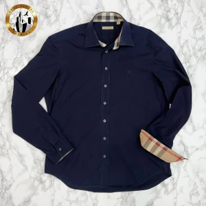 Burberry Skjorta L - Marinblå Burberry skjorta i storlek L i begintligt skick. Skjortan är självklart äkta. Är du osäker på äkthet hänvisar jag gärna till bra källor/guider. Tveka inte på att höra av dig för fler frågor eller vid minsta fundering! Skick: 7,5/10