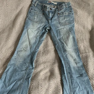Bootcut jeans i ljusblå denim från ONLY - Bootcut jeans från ONLY denim. St 38 längd 32. De är vintage. Saknar knapp på högerbakficka